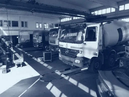 Werkstatthalle von WERA mit mehreren Lkw, darunter ein Betonmischer, unter der roten Kranbahn